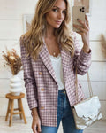 Woman taking a mirror selfie wearing a plaid tweed double breasted blazer and jeans.